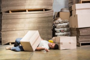 A worker lying on the floor injured after being hit by a falling object