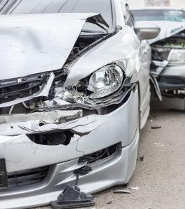 Two cars which have sustained serious frontal damage after a road traffic accident.