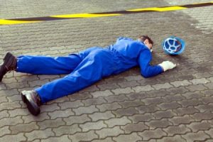 A contractor on the pavement face down after suffering a self employed accident at work. 