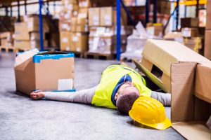 Injured worker lies on the floor after being hit by falling boxes 