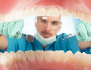 A dentist from the perspective of inside of a mouth.