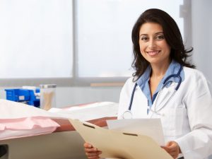 A doctor in a white coat holding a medical document.