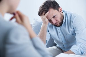 Man suffering from mental health injuries speaking to a psychiatrist