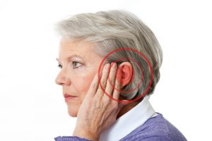 Woman holding painful ear affected by tinnitus