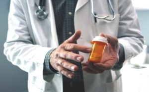 A doctor holding a pill bottle.