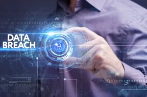 A man holding a digital sphere in his fingers with the words 'data breach' hovering next to it.