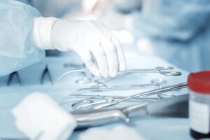 A surgeon reaching for surgical tools.