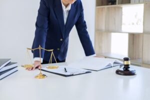 A solicitor standing behind a desk and explaining how to sue a hospital for negligence.