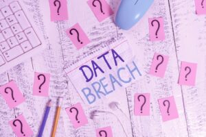 Note With The Word Data Breach On A Table With Pencils And Further Notes With Question Marks. 