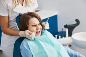 Young patient uncomfortable while receiving dental treatment
