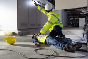 A man in a high-vis jacket calls for help for an unconscious colleague
