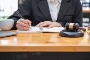 a no win no fee solicitor working at a desk with a gavel hammer and coffee mug