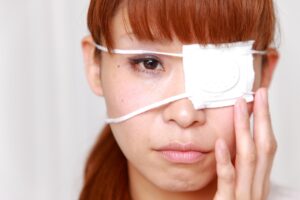 A woman with a bandage over her eye after negligent eye treatment.