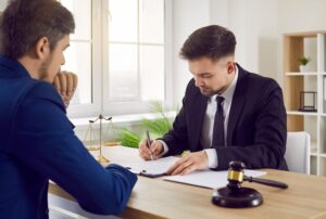 A solicitor and their client at a desk discussing an office accident claim.