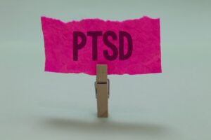 A peg holding a pink piece of paper with the PTSD written in block capitals. 