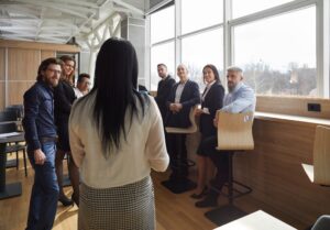 An employee facing away from the camera and talking to a group of colleagues.