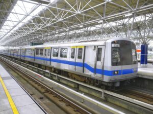 A grey train at a platform in a train station. 