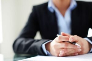 Car accident claim solicitor sat at a desk and holding a pen