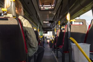 The inside of a bus and passengers taken from the back. 