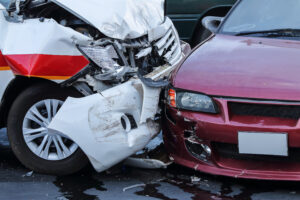 Two cars show visible damage after a collision on a street.