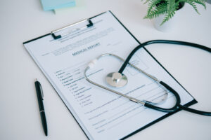 A medical report lays on a desk with a stethoscope on top.