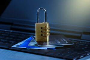 Padlock on and credit cards stacked on top of a laptop, representing the financial risk that can come with a personal data breach. Financial losses could be recovered through data breach compensation for a valid claim