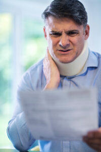Man wearing neck brace after a severe whiplash injury examines the medical evidence for his personal injury claim