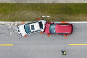 Two cars show visible damage after a collision on the side of a road.