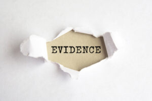 The word evidence to prove laser eye surgery negligence occurred appearing behind torn paper. 