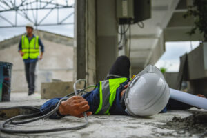 Man on floor after electric shock at work from wire.
