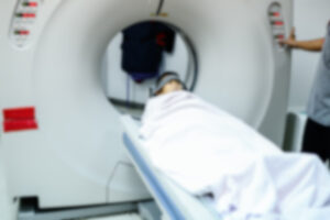 A patient lays on a table while undergoing a brain scan.