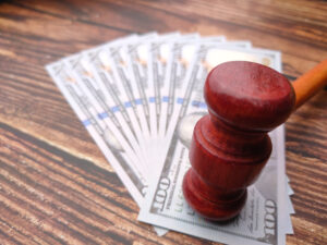 A gavel on top of spread out bank notes to represent bicycle accident compensation.