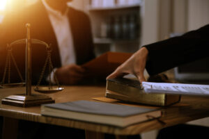 A finger injury claim solicitor sat at a desk with legal books