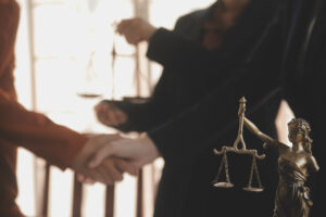 2 taxi accident claims solicitors shaking hands next to justice scales. 