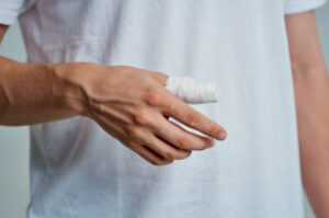A hand with a bandaged thumb.