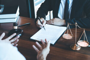 An e-scooter accident claims solicitor sat at a desk with a client going through a contract.