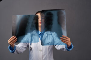 A doctor looks at two different scans of a patient.