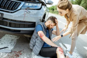 A woman helps a cyclist who has been hit by a car.