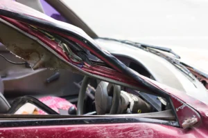 A red car showing damage after an accident.