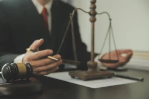 A hit and run claims solicitor working on a claim at their desk with a set of judgement scales.