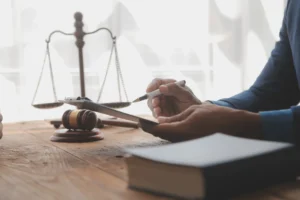 A solicitor working in their office on a nose injury compensation claim with a set of scales and gavel